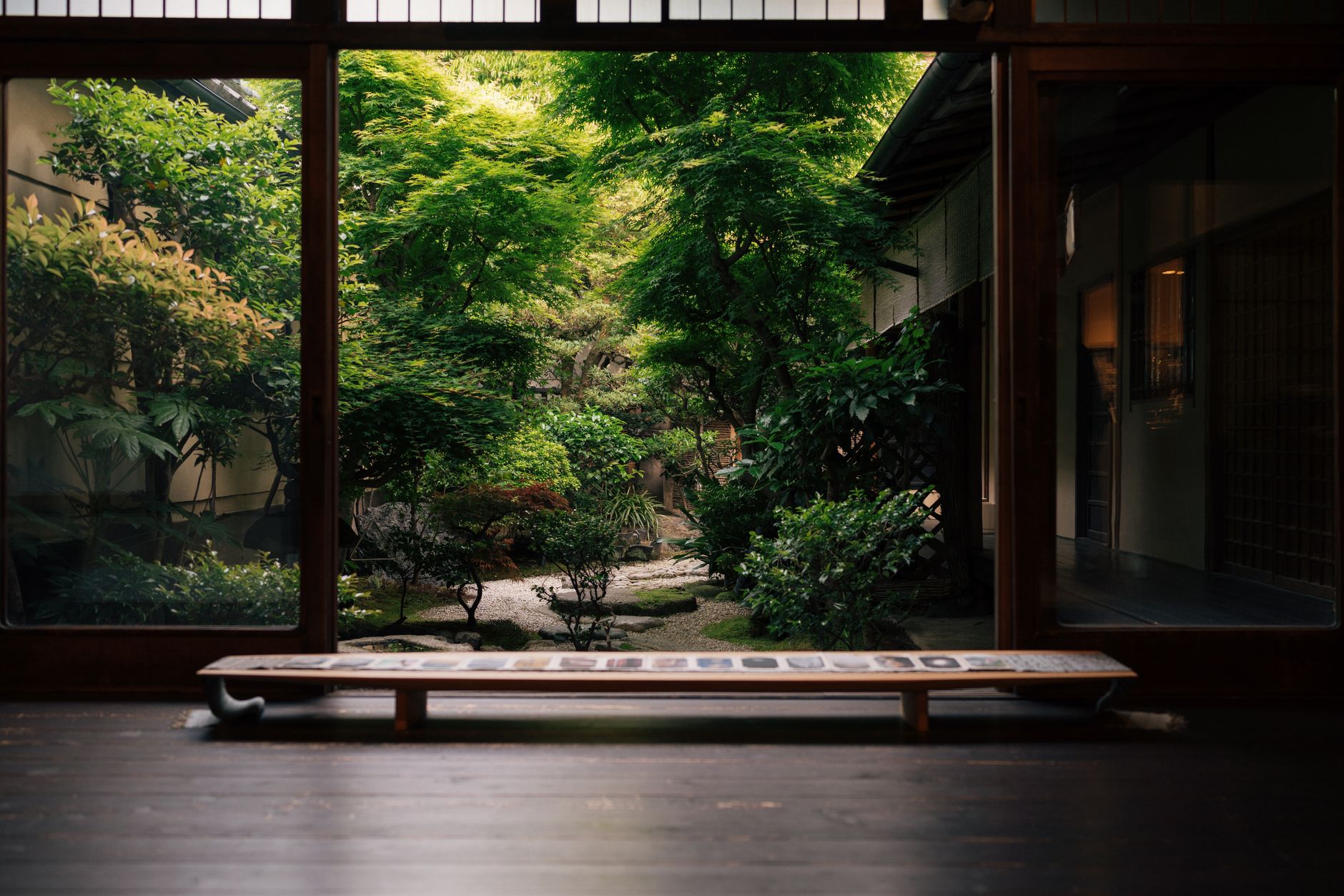 Intricate tatami room with shoji screens sliding open to an autumnal Japanese garden