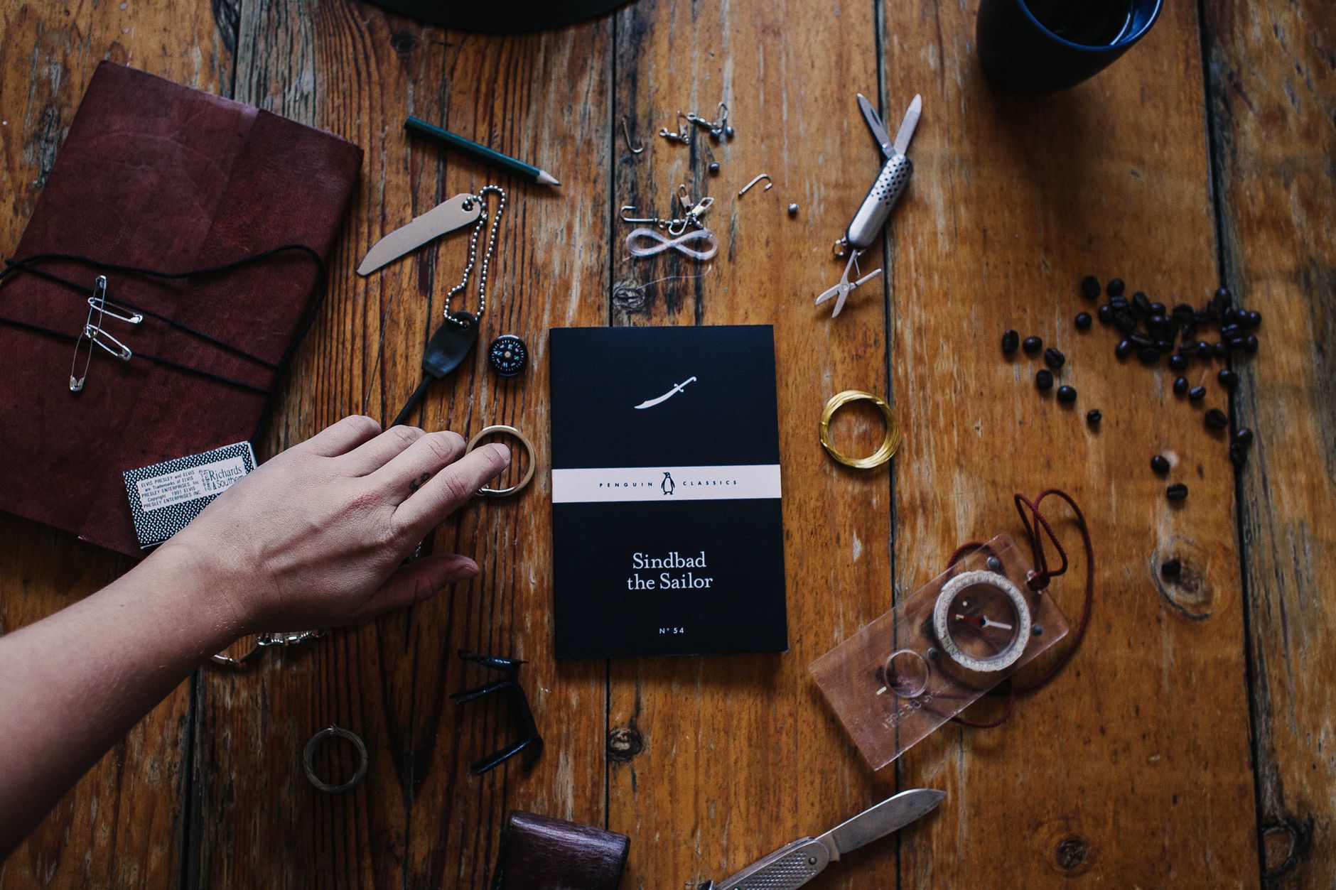 Hand-bound travel itinerary notebook and compass on wooden table